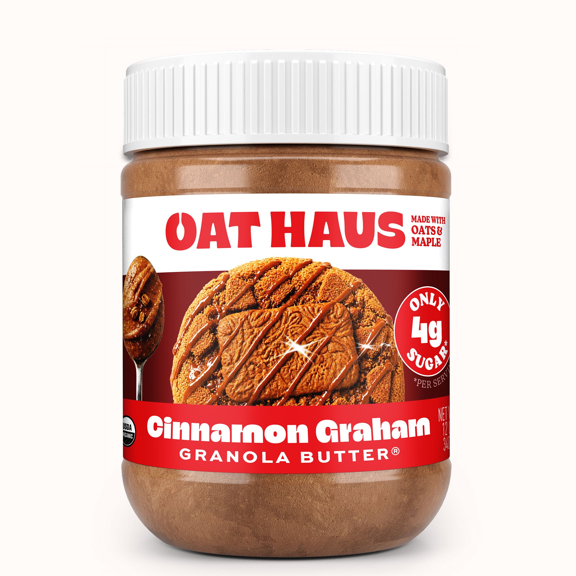 A jar of Oat Haus Cinnamon Graham Granola Butter on a clean white background. The product features a white ribbed cap, a clear plastic jar showing the brown granola butter inside, and a label with red and white sections displaying a cookie and the brand name.